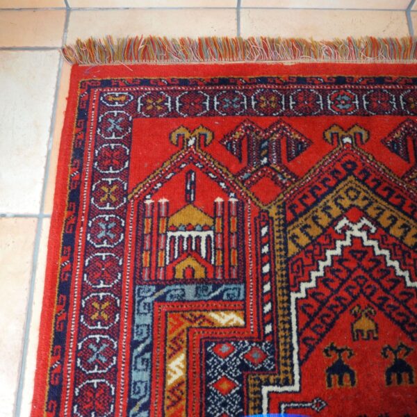 tapis en laine décors orientaux couleurs rouge-orange un angle vue de près